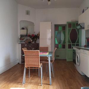 a kitchen with a table and chairs in a room at Charme et jardin in Toulouse