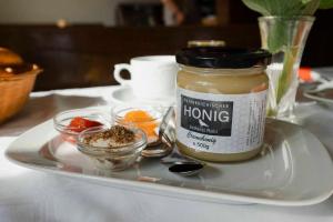 a plate with a jar of honey on a table at Gasthof Speneder in Altpölla
