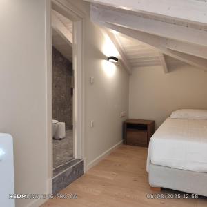 a bedroom with a white bed and a mirror at Dimitris's & Evangelia's Loft Homes with Garden, Near Airport & Town in Agios Rokkos