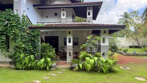 a white house with plants in front of it at Villa Samas in Galle