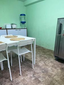a white table and chairs in a kitchen with a refrigerator at Cozy Haven 1018 Homestay in Shillong
