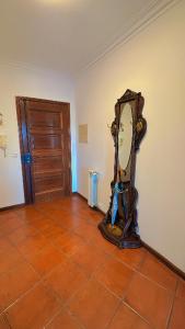 a clock sitting on the floor in a room at Quarto duplo com varanda no centro de Viseu in Viseu +9 photos