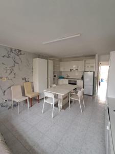una cucina con tavolo e sedie bianchi di Residence Los Molinos a Maspalomas