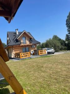 a log cabin with a car parked in front of it at Bajkowa Chatka in Bodzentyn