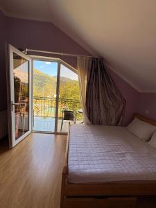 ein Schlafzimmer mit Bett und Balkon mit Aussicht in der Unterkunft cottage in tsemi (Borjomi) in Bordschomi