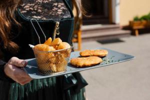 a woman holding a tray with food on it at Gasthof Speneder in Altpölla +35 photos