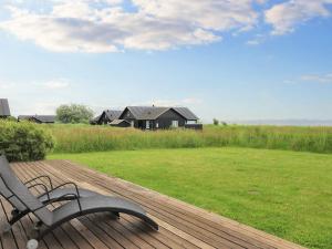 een bank bovenop een houten terras bij Holiday home near Nysted in Nysted