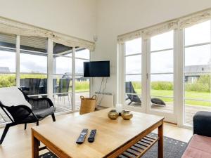 a living room with a table and chairs and windows at 4 star holiday home in Nysted in Nysted +46 photos