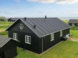een zwart huis met een gambrel dak bij Holiday home near Nysted in Nysted