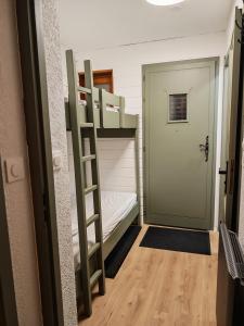 a bunk bed in a small room with a door at Le Bon' Appart studio proche centre Châtel in Châtel