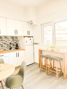 a kitchen with white cabinets and a table and chairs at Apartamento Susurros do Atlántico by ALÔGA in Fisterra