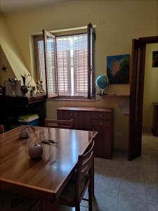 een eetkamer met een houten tafel en een groot raam bij Bed and Breakfast La Campanula in Vittorito