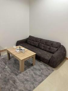 a brown couch in a living room with a coffee table at شقق رحابة المكان للشقق المفروشه in Al Kharj