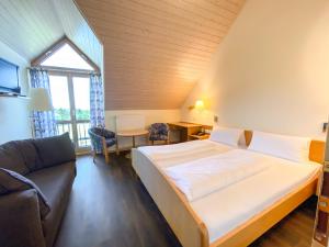 a bedroom with a large bed and a couch at Berggasthof Höchsten in Illmensee +42 photos