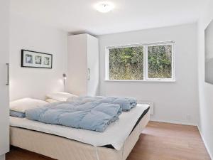 a bedroom with a large bed with a window at 5 star holiday home in Blokhus in Blokhus