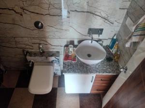 a bathroom with a sink and a toilet at Vassu Bhavan in Bharwain