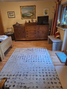 a living room with a dresser and a television at Ferienwohnung in Sauerlach