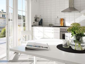 a white kitchen with a table with a book on it at 4 person holiday home in Skärhamn-By Traum in Skärhamn