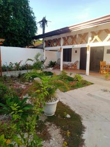 a house with a courtyard with plants in it at Malapasqua Island Cottage Holiday House in Daanbantayan