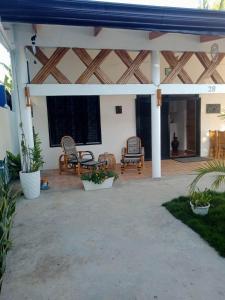 a patio with wicker chairs and tables in a house at Malapasqua Island Cottage Holiday House in Daanbantayan +13 photos
