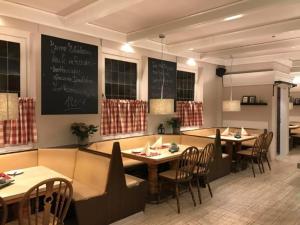 a dining room with tables and chairs and a chalkboard at Hotel Restaurant Strümper Hof in Meerbusch