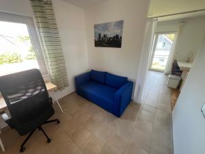 a blue couch in a living room with a window at Buschwiesen Ausguck in Teltow