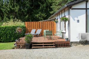 a wooden deck with two chairs on top of it at Le Rensy in Ferrières