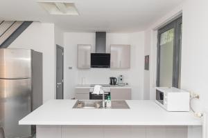a white kitchen with a sink and a refrigerator at Secret garden in Mellehoek