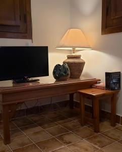 a desk with a television and a lamp on it at Casa Rural Mar de Encinas in Cabañas del Castillo