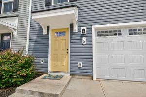 a house with a yellow door and a driveway at Modern DownTown Retreat Near Swamp Rabbit Trail townhouse in Travelers Rest