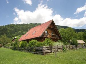 a log cabin with a red roof in a field at Chalet in Einach nahe Skipisten in Einach