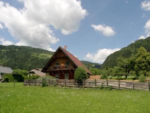 a wooden house in a field next to a fence at Chalet in Einach nahe Skipisten in Einach