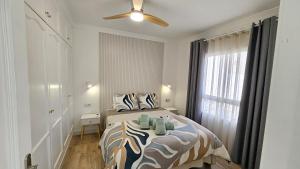 Un dormitorio con una cama y un ventilador de techo. en Apartamento Playa Gran Tarajal, en Gran Tarajal