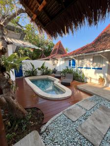 Un patio trasero con piscina y una casa. en Villa AnTeak, en Gili Air