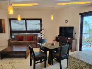 a living room with a table and a couch at Beach Front - Ocean View 1 BR Condo w Terrace & Hughe Infinity Pool Heart of Playa del Carmen in Playa del Carmen