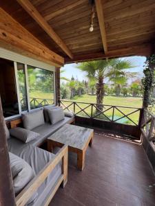 un porche cubierto con un banco y una mesa en Charmant Chalet calme et moderne, en Dar Mohammed Ould Haj Jilali 5 fotos más