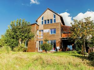 a large wooden house on a hill with trees at Villa mit Sauna und Garten in Schotten