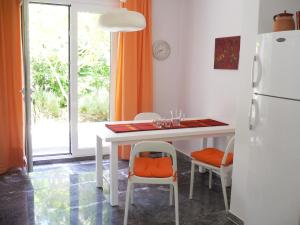 a kitchen with a white table and a refrigerator at Flower Garden in Mati