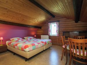 a bedroom with a bed and a table and chairs at Cozy Chalet in Francorchamps in Francorchamps