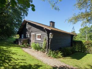 an old wooden house in a grassy field at Cozy Chalet in Francorchamps in Francorchamps