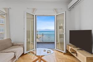 a living room with a couch and a flat screen tv at Central Beachfront Apt with a Breathtaking View! in Chalkida