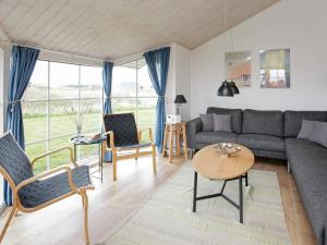 a living room with a couch and chairs and a table at 8 person holiday home in Løkken-By Traum in Løkken