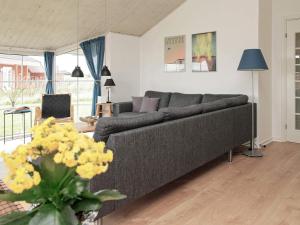 a living room with a gray couch and yellow flowers at 8 person holiday home in Løkken-By Traum in Løkken +19 photos