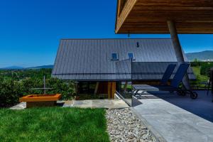a house with a table and chairs on a patio at Czorsztyn Prestige Ville in Kluszkowce