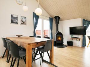 a dining room with a table and chairs and a fireplace at 8 person holiday home in Løkken-By Traum in Løkken