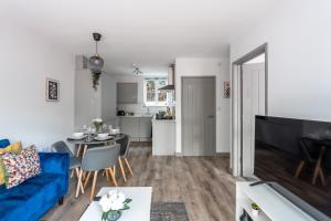 ein Wohnzimmer mit einem blauen Sofa und einem Tisch in der Unterkunft 4Beds Contractor and Family Haven near Pinewood and Warner Bro studios in Chalfont Saint Peter