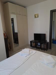 a bedroom with a bed and a tv and a mirror at White home-apartament in Burgas