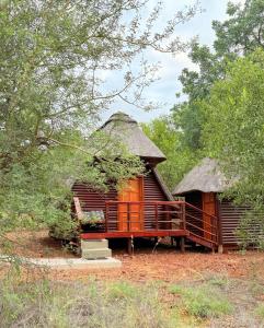 a large wooden cabin with a thatched roof at Tsakane Safari Camp in Hoedspruit