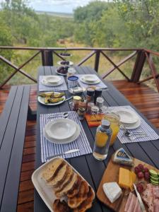 a picnic table with food and drinks on a deck at Tsakane Safari Camp in Hoedspruit