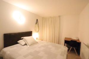 Un dormitorio con una cama y un escritorio. en Chambre proche Montmartre, en París